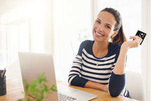 Woman Smiling with Credit Card in Hand